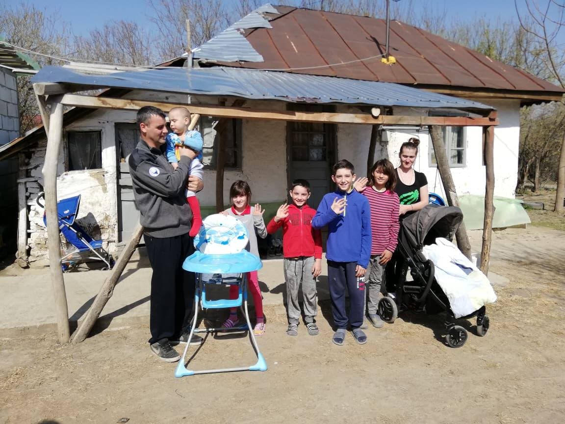 Familie numeroasă în fața casei, sprijinită de Asociația Șansa Ta