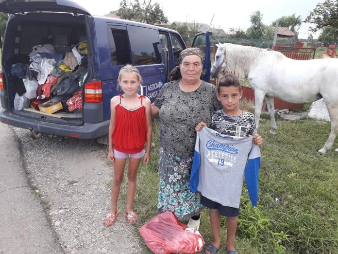 Haine donate, distribuite unei familii din proiectul Îmbracă un Suflet